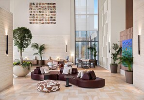 A spacious lobby with a modern design, featuring a large seating area, a dining table, and potted plants. - Akra Didim Resort & SPA (Didim)