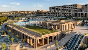 Un hotel con piscina en la azotea, mobiliario exterior y un diseño arquitectónico moderno.