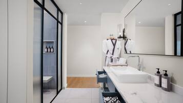 A modern bathroom with a white sink, a mirror, and a towel rack.