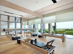 A Pilates studio with mirrored walls, wooden floors, and large windows offering a view of the outdoors. - Akra Didim Resort & SPA (Didim)