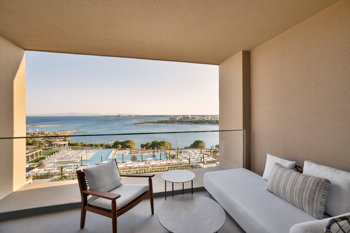 Un balcone con vista su una piscina e il mare.