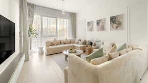 Een moderne woonkamer met een beigekleurige zithoek, een salontafel en een televisie.