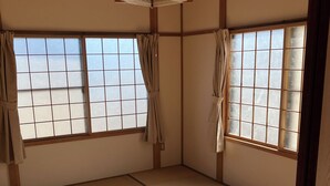 Um quarto japonês tradicional com tatames, portas deslizantes shoji e um painel shoji suspenso.