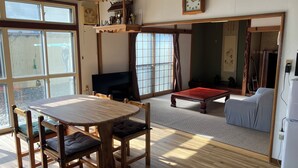 Um quarto tradicional em estilo japonês, com tatames, uma mesa de tatame e uma mesa de madeira baixa.