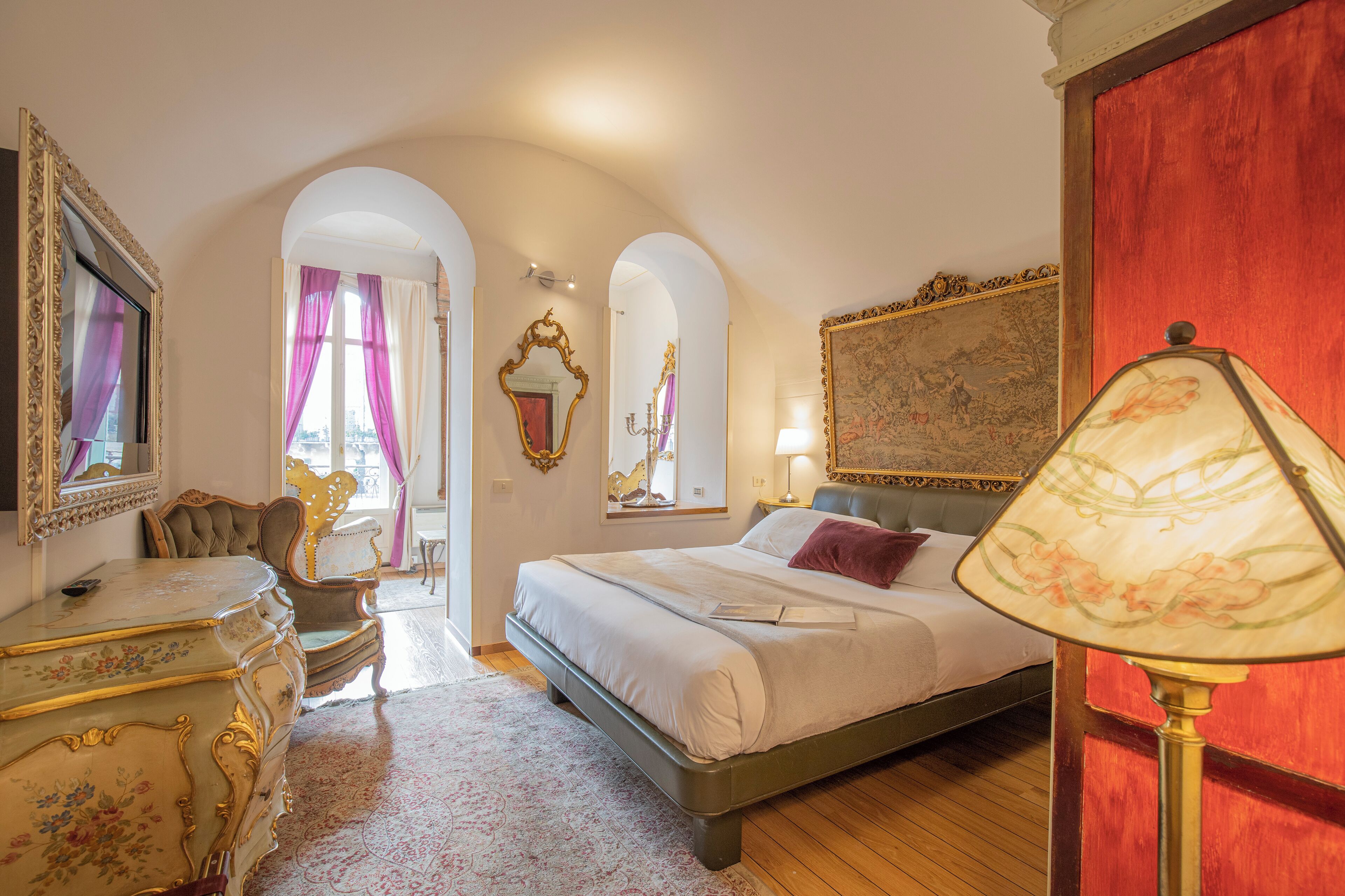 A bedroom with a bed, a dresser, a chair, a lamp, and a mirror.