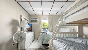 A room with bunk beds, a desk, a fan, and a window with curtains. - Oceanfront condos with 3 night minimum rentals and linens included! (Ocean City)