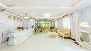 A spacious lobby with a marble reception desk, comfortable seating, and a large mirror. - Chaleunxay Hotel (Vientiane)