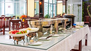 A buffet setup with multiple serving stations and a variety of dishes. - Chaleunxay Hotel (Vientiane)