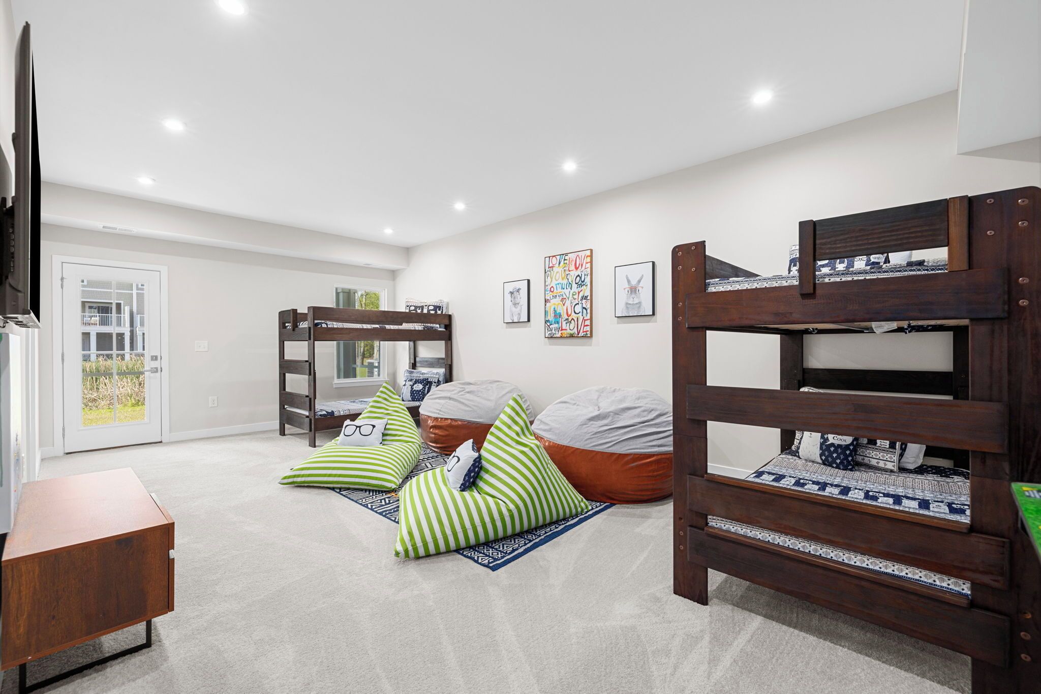 A cozy room with bunk beds, a small table, and a door leading to a balcony.