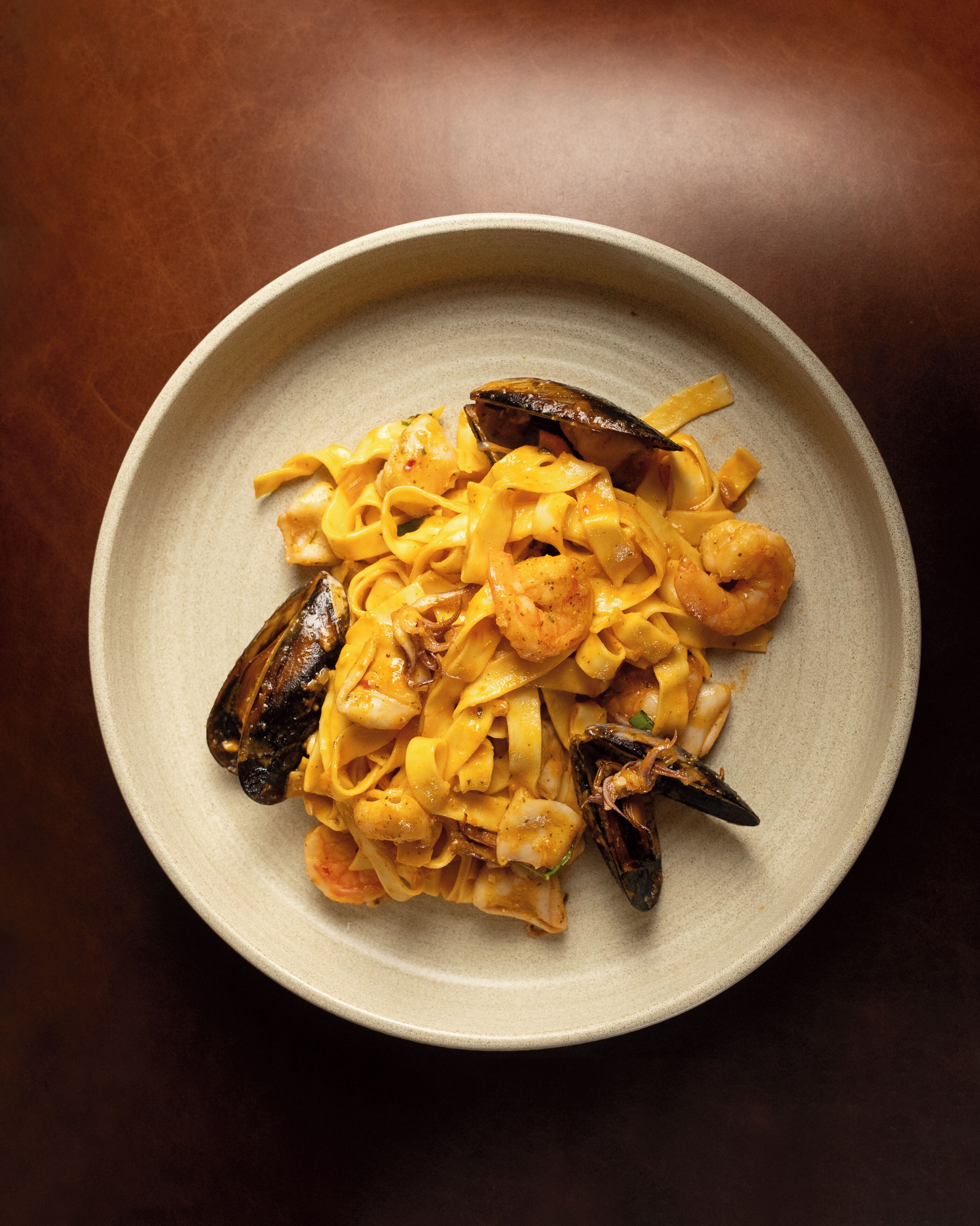 Un plato de pasta con mariscos, mejillones y camarones.