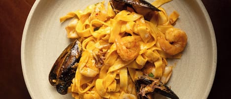 Un plato de pasta con mariscos, mejillones y camarones.