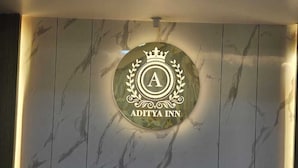 Paret de marbre amb el logotip d'Aditya Inn.