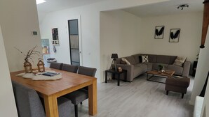 Un espacio habitable moderno con comedor, sofá y mesa de centro.