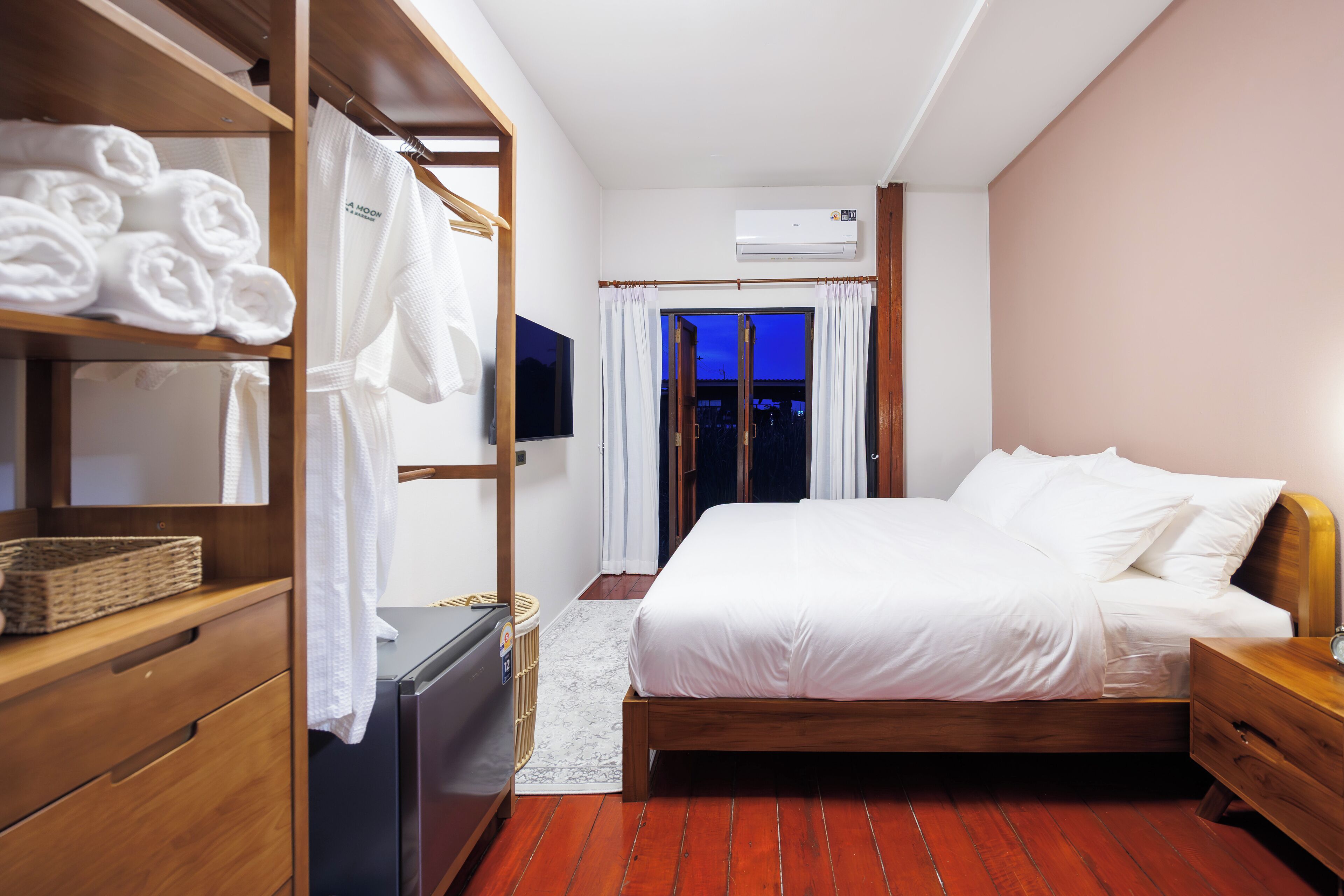 Une chambre d’hôtel bien rangée, avec un lit, une armoire en bois et un téléviseur.