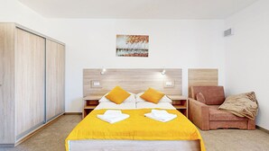 Ein Schlafzimmer mit einem Bett, einem Nachttisch, einem Sessel und einem Kleiderschrank.