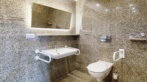 Ein Badezimmer mit Marmorwaschtisch, Toilette und Spiegel.