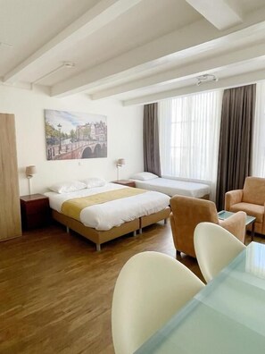 A hotel room with a bed, a desk, a chair, and a painting on the wall. - Hotel Residence Le Coin (Amsterdam)