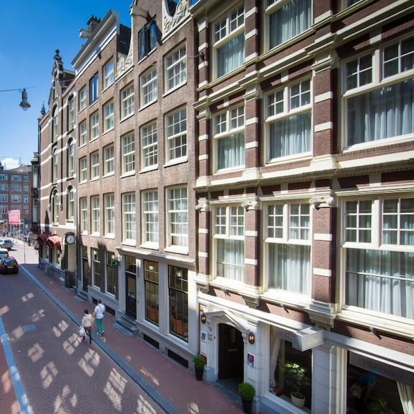 A row of traditional brick buildings with large windows and a clear sky.