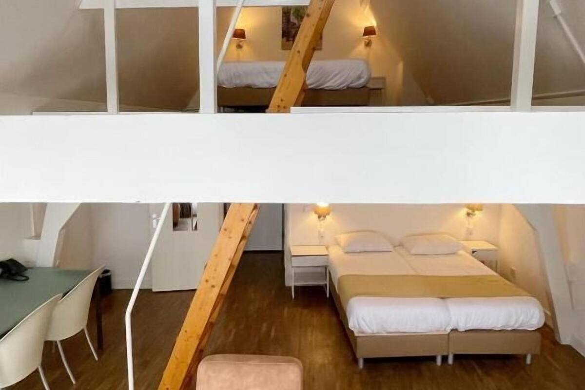 Un dormitorio estilo loft con literas, un escritorio y una silla.
