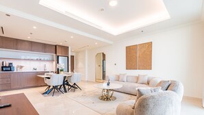 Una sala de estar moderna con un sofá, una mesa de comedor y una zona de cocina con armarios y electrodomésticos.