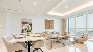 Una sala de estar moderna con comedor, ventanas amplias y vista a la ciudad.