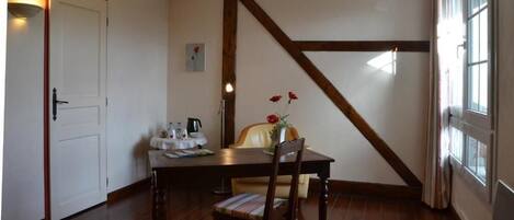 Un comedor con una mesa y sillas de madera, una puerta blanca y una ventana con cortinas.