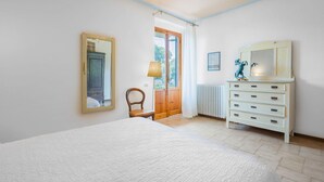 A bedroom with a bed, a dresser, a chair, a mirror, and a window. - Stunning private villa with WIFI, A/C, private pool, TV, patio, pets allowed, close to San Gimignano (Montaione)