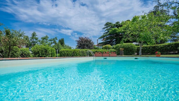 A clear swimming pool surrounded by lush greenery and a clear sky. - Stunning private villa with WIFI, A/C, private pool, TV, patio, pets allowed, close to San Gimignano (Montaione)