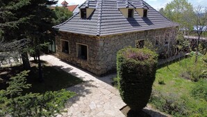 A stone house with a tiled roof, two small windows, and a chimney. - Holiday Home 'Los Ciegos' with Mountain View, Private Terrace and Wi-Fi (Peguerinos)