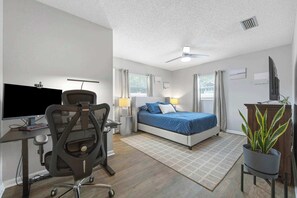 A hotel room with a desk, chair, bed, and a potted plant. - Casa Playa Private Home for 6! (St. Augustine)