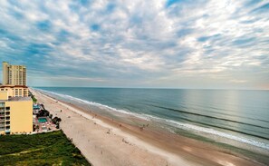 A beach with a hotel and ocean view.