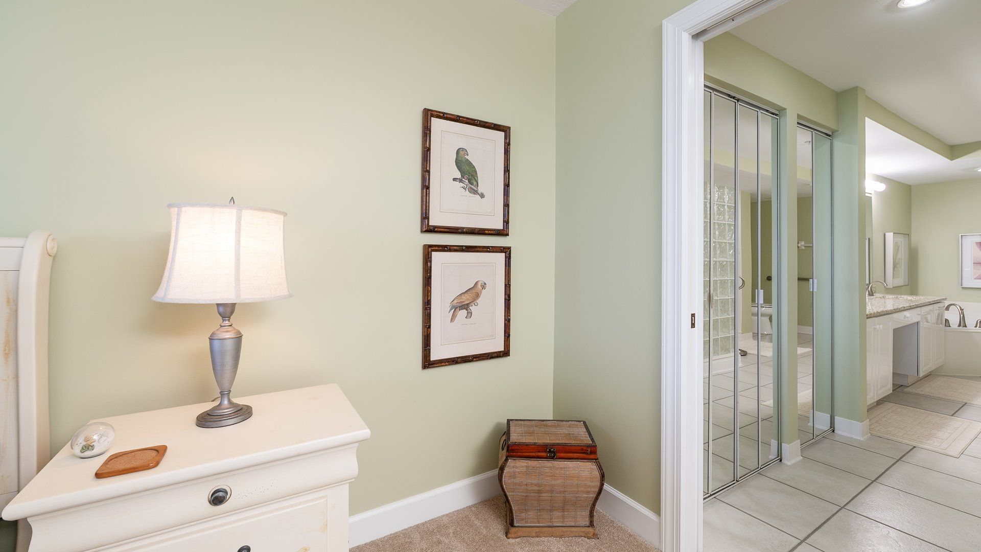 A bathroom with a vanity, a mirror, and framed bird illustrations on the wall.