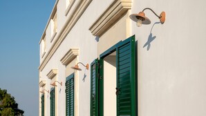 A building with green shutters and wall-mounted lighting fixtures. - Room 'San Biagio - Superior 105' with Shared Pool, Wi-Fi & Air Conditioning (Calimera)