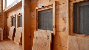 Wooden walls with multiple windows, each with a mesh screen. - Room 'San Biagio - Superior 105' with Shared Pool, Wi-Fi & Air Conditioning (Calimera)
