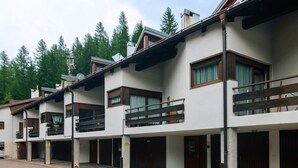 Una fila di edifici moderni a più piani, con balconi, ampie finestre e un piazzale lastricato in pietra.
