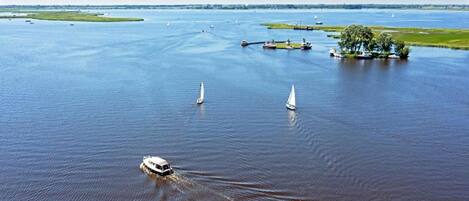 A river with boats and a small island with trees.