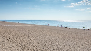 A beach with a clear sky, a sandy shore, and umbrellas. - Apartment 'I Ciottoli Dello Ionio - Apt 1' with Mountain View, Shared Terrace and Balcony (Mascali)