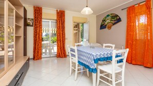A dining area with a table set for four, white chairs, and a blue tablecloth. - Apartment 'I Ciottoli Dello Ionio - Apt 1' with Mountain View, Shared Terrace and Balcony (Mascali)