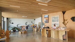 A spacious room with a wooden reception desk, a clothing rack, and a tent-like structure. -  Pana Unique Charyn (Charyn Canyon)