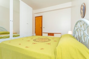 Une chambre à coucher avec un lit, une armoire, un bureau et un miroir.
