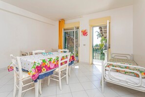 Une pièce comprenant une table à manger, des chaises, un lit et un balcon avec vue.