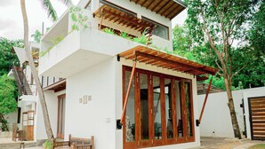 A modern two-story building with a wooden deck, a bench, and a staircase. - The Rivergates Villa (Panadura)