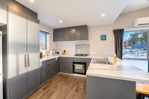 Una cocina moderna con armarios grises, un microondas, una estufa y un lavaplatos.