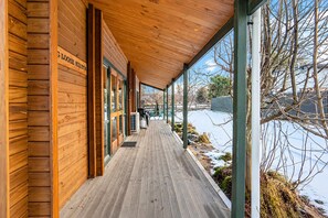 En træbygning med en overdækket veranda, store vinduer og et skilt med teksten 'LOOSE HILLTON'.