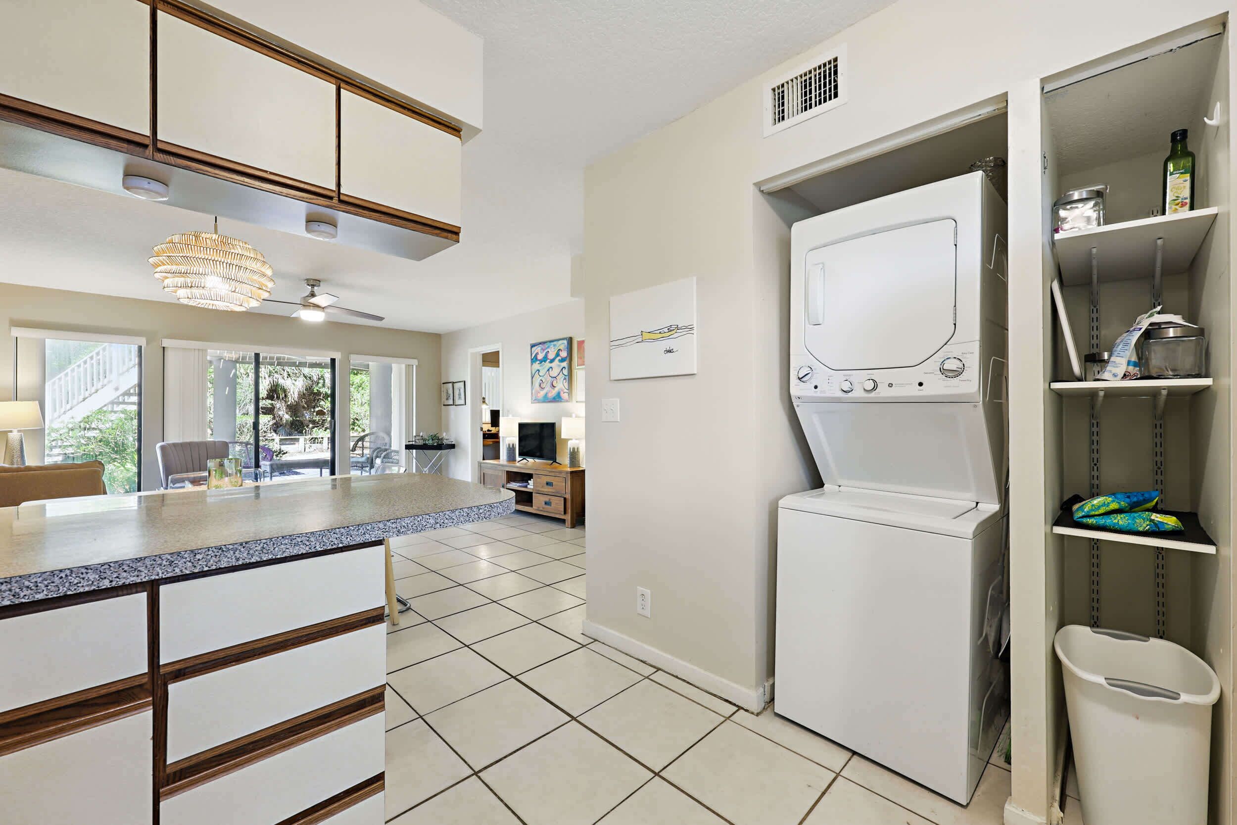 A modern kitchen with a built-in oven, a countertop with a sink, and a dining area with a table and chairs.