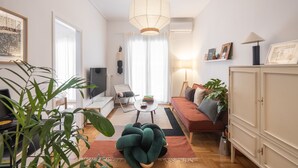 Un salon moderne avec un canapé, une table basse et une grande plante.