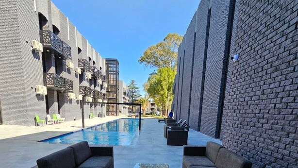 A poolside area with outdoor seating and a clear view of the pool. - The Lakewood Hotel  (Johannesburg South)