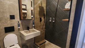 A modern bathroom with a toilet, sink, and shower. - The Lakewood Hotel  (Johannesburg South)