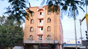 A multi-story building with a sign for 'Saklhi Hotels' and 'Cheerful Bar'. - Sakthi Hotel (Pollachi)