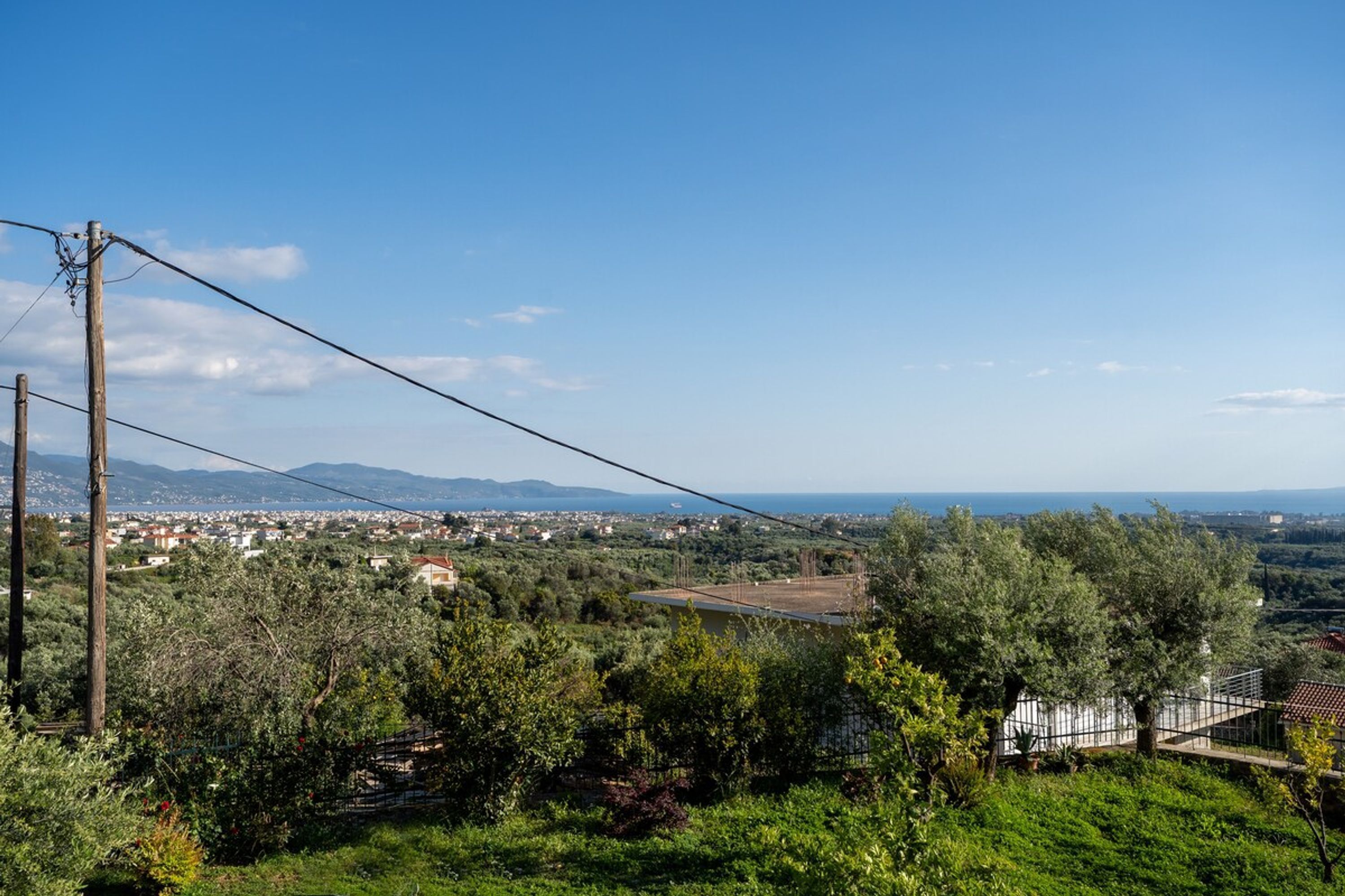 Ländliche Landschaft mit Blick auf eine Stadt, Stromleitungen und einer Brücke.